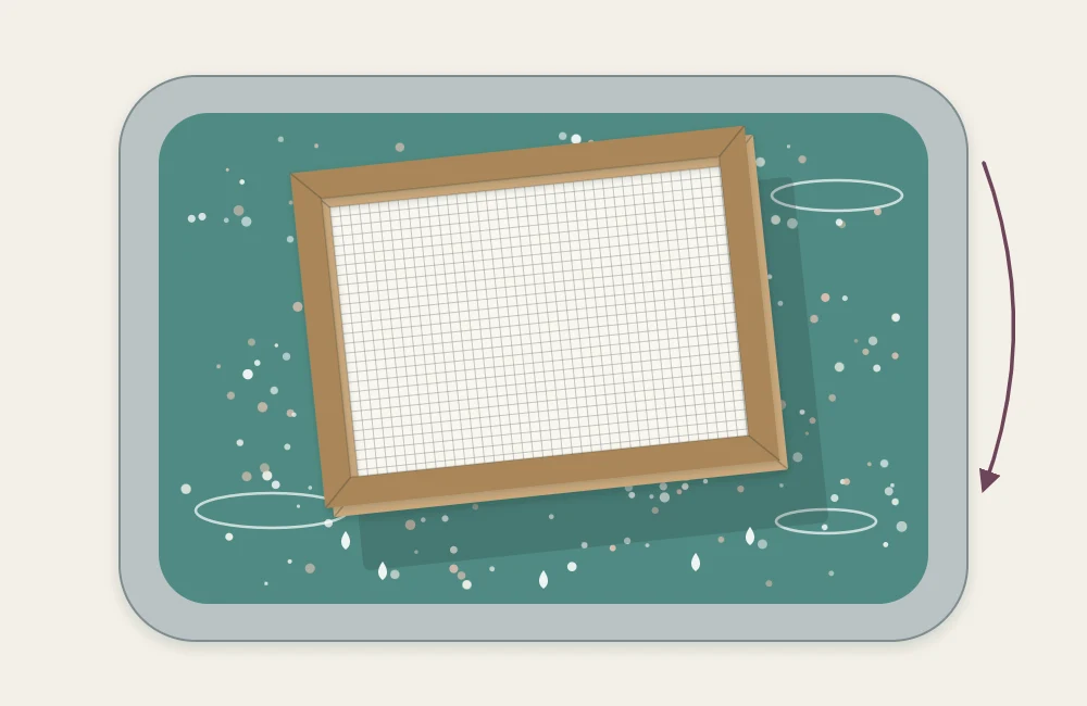 A mould and deckle held level above a tub of paper pulp and water