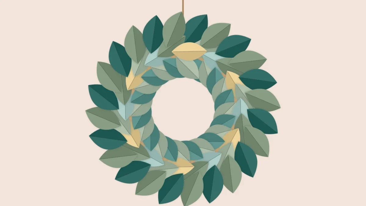 Wreath of layered paper leaves in several green tones arranged around a ring